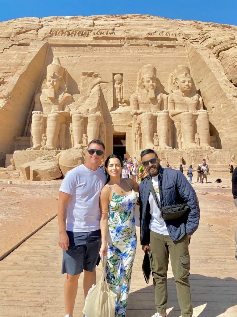 Tres viajeros frente a los colosos de Ramsés II en la fachada del Gran Templo de Abu Simbel