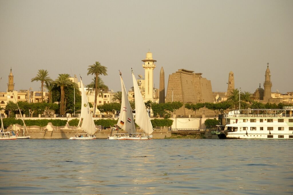 Crucero por el Nilo en diciembre junto a los templos de Luxor con felucas de vela blanca y luz dorada al atardecer