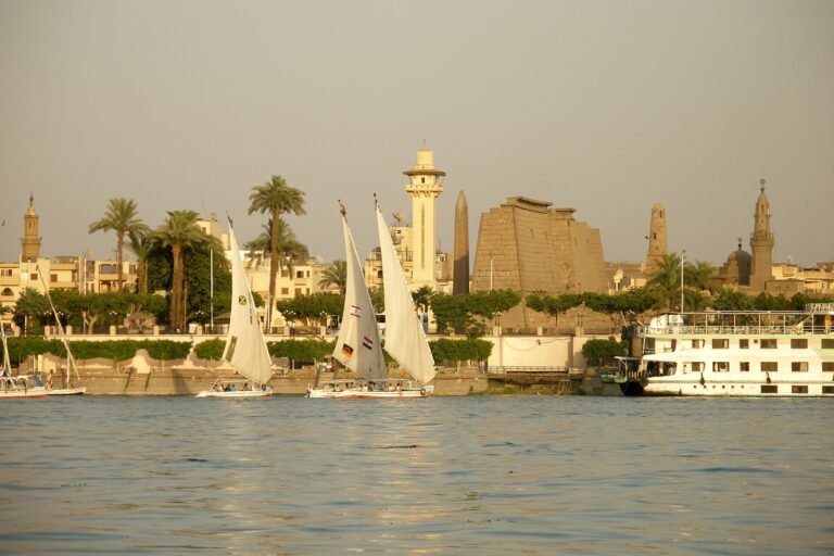 Crucero por el Nilo en diciembre junto a los templos de Luxor con felucas de vela blanca y luz dorada al atardecer