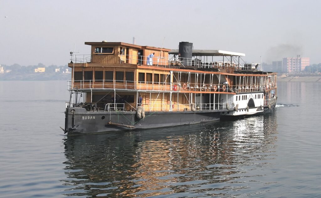 Barco crucero clasico de madera navegando por el rio Nilo en Egipto durante un crucero por el Nilo
