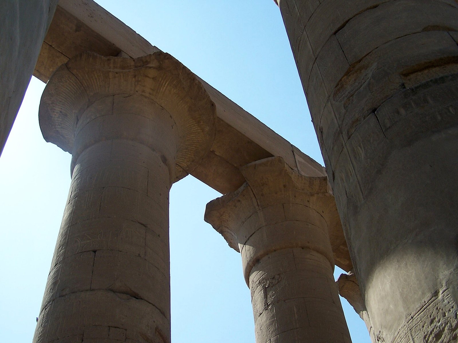 Capiteles de las grandes columnas del Templo de Karnak vistos desde abajo contra el cielo azul
