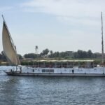 Dahabiya tradicional con gran vela latina blanca desplegada navegando por el Nilo en Egipto
