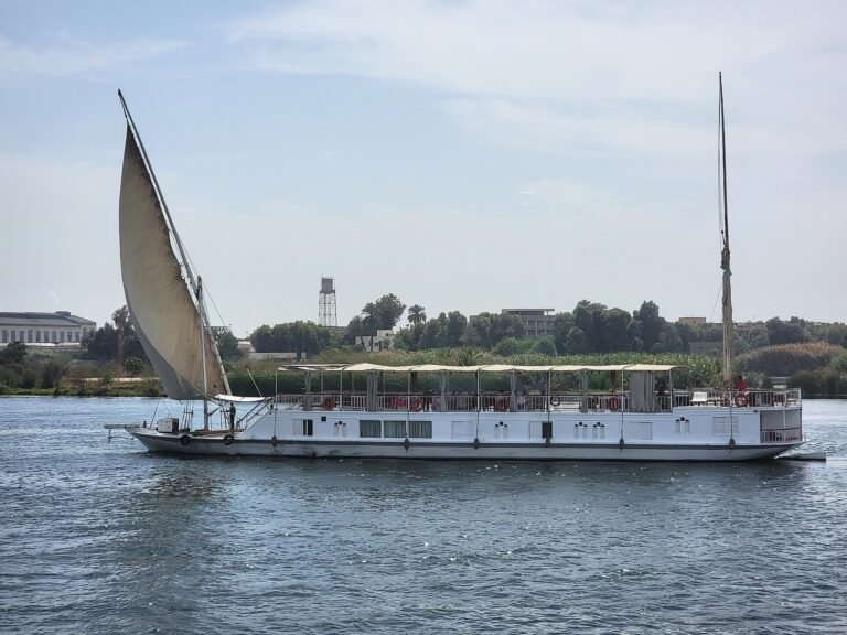Dahabiya tradicional con gran vela latina blanca desplegada navegando por el Nilo en Egipto