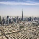 Vista aerea de Dubai con el Burj Khalifa dominando el horizonte de rascacielos modernos bajo un cielo azul, ciudad premium de Emiratos