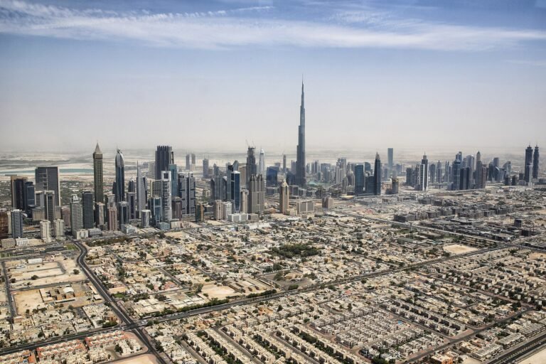 Vista aerea de Dubai con el Burj Khalifa dominando el horizonte de rascacielos modernos bajo un cielo azul, ciudad premium de Emiratos
