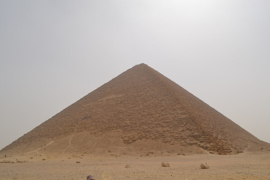 La Piramide Roja de Dahshur se eleva simetrica sobre el desierto abierto bajo un cielo despejado, una de las grandes piramides lisas del antiguo Egipto