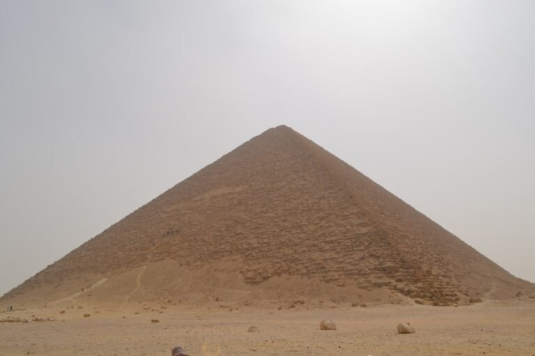 La Piramide Roja de Dahshur se eleva simetrica sobre el desierto abierto bajo un cielo despejado, una de las grandes piramides lisas del antiguo Egipto