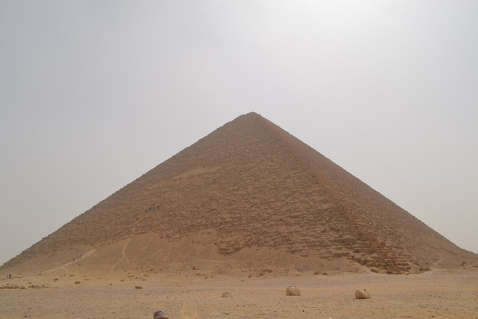 La Piramide Roja de Dahshur se eleva simetrica sobre el desierto abierto bajo un cielo despejado, una de las grandes piramides lisas del antiguo Egipto
