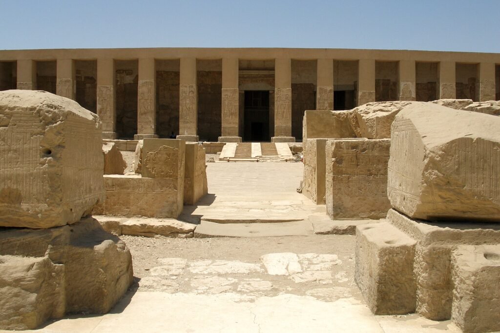 Fachada del templo de Seti I en Abydos en Egipto con su columnata de pilares en piedra arenisca dorada bajo un cielo azul despejado
