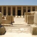Fachada del templo de Seti I en Abydos en Egipto con su columnata de pilares en piedra arenisca dorada bajo un cielo azul despejado