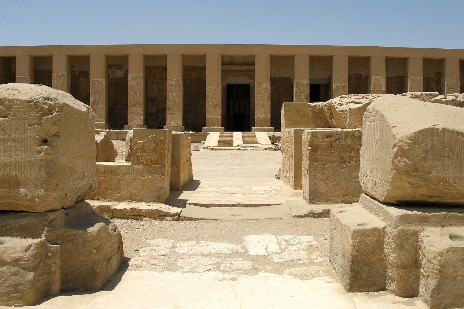 Fachada del templo de Seti I en Abydos en Egipto con su columnata de pilares en piedra arenisca dorada bajo un cielo azul despejado
