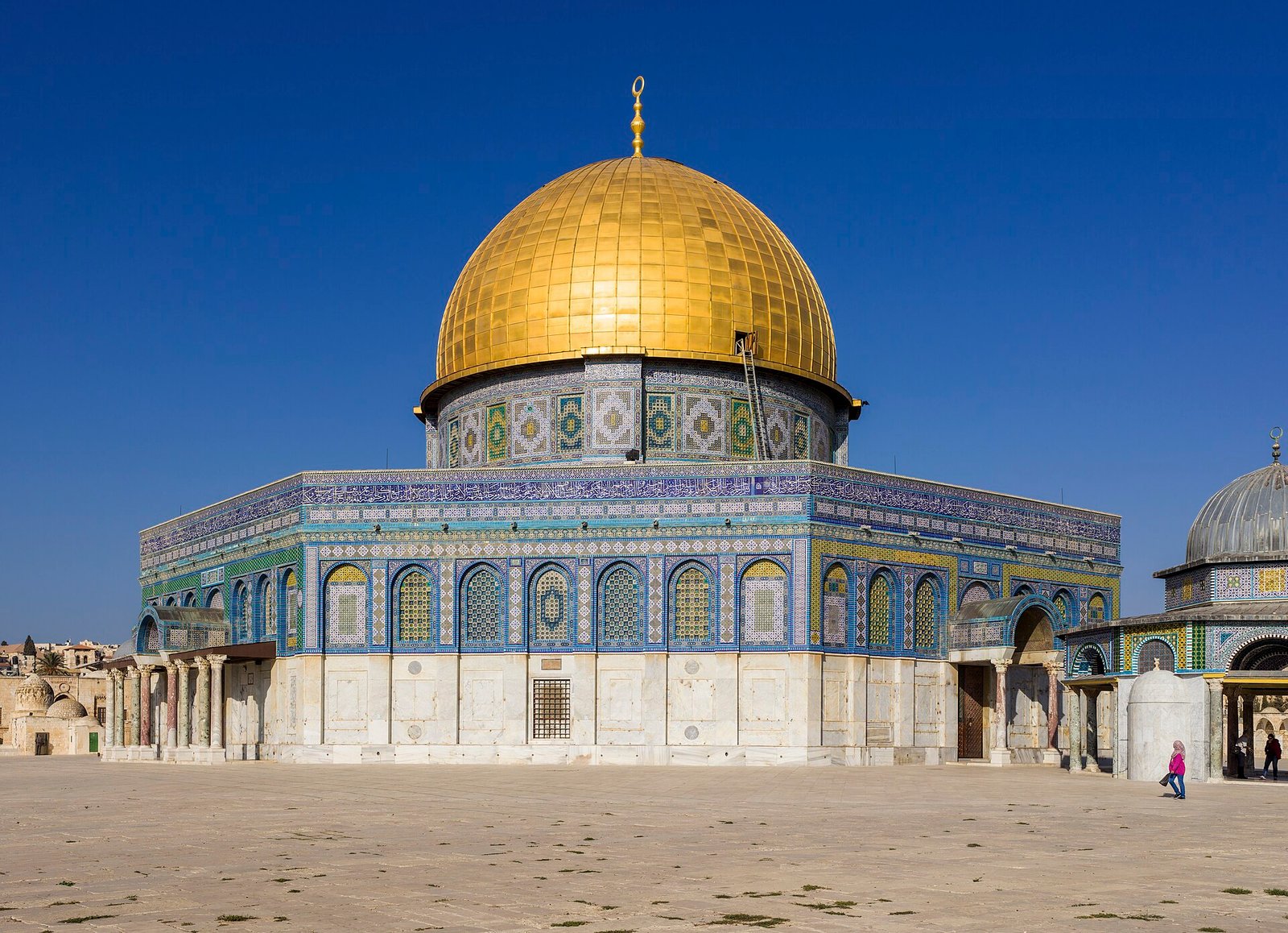 La Cupula de la Roca dorada en la Ciudad Vieja de Jerusalen, Tierra Santa, con su base octogonal de mosaicos azules bajo un cielo despejado
