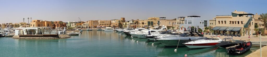 Vista panoramica de la laguna turquesa de El Gouna en Egipto con numerosos yates de lujo amarrados frente a edificios ocre estilo nubio del Mar Rojo