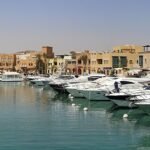 Vista panoramica de la laguna turquesa de El Gouna en Egipto con numerosos yates de lujo amarrados frente a edificios ocre estilo nubio del Mar Rojo