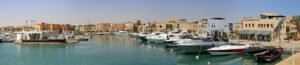 Vista panoramica de la laguna turquesa de El Gouna en Egipto con numerosos yates de lujo amarrados frente a edificios ocre estilo nubio del Mar Rojo