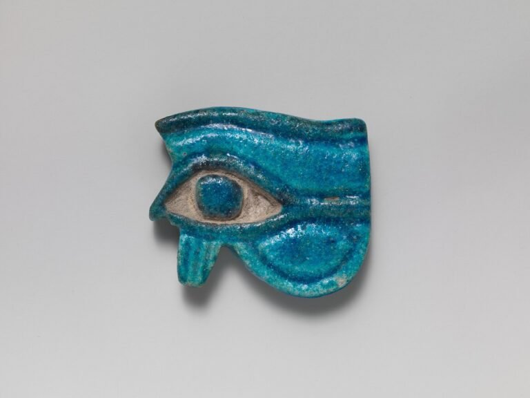 Amuleto wedjat egipcio en fayenza turquesa vidriada, con ceja, ojo y pupila bien definidos, simbolo protector del Ojo de Horus sobre fondo neutro