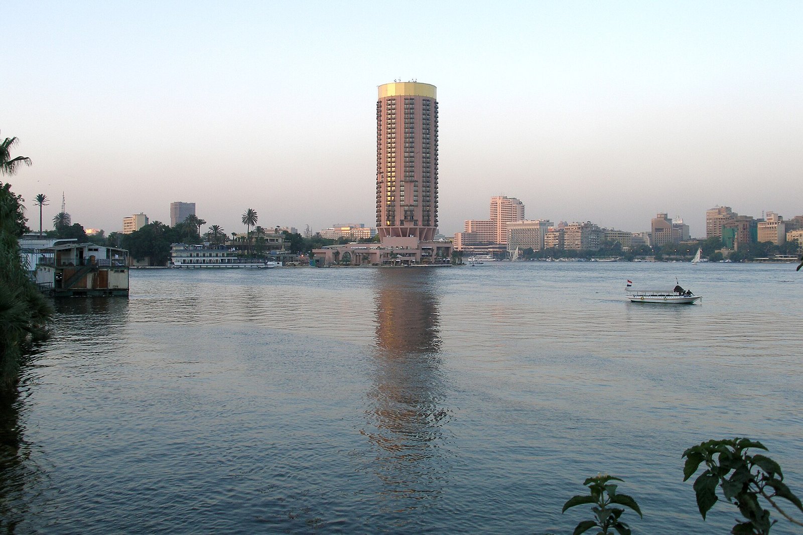Torre de El Cairo y veleros sobre el rio Nilo con la ciudad al fondo en luz dorada