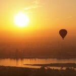 Globo aerostático sobrevolando Luxor y el río Nilo al amanecer dorado, Alto Egipto