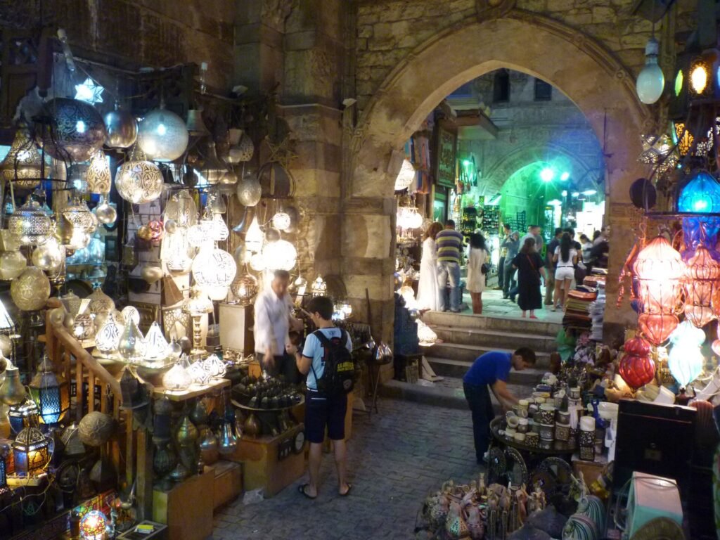 Callejon del bazar Khan el-Khalili en El Cairo, Egipto, con faroles dorados encendidos, lamparas ornamentadas y arcos de piedra historicos al fondo