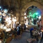 Callejon del bazar Khan el-Khalili en El Cairo, Egipto, con faroles dorados encendidos, lamparas ornamentadas y arcos de piedra historicos al fondo