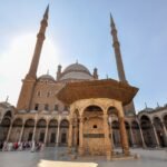Mezquita de Alabastro de Muhammad Ali en la Ciudadela de El Cairo, Egipto, con sus dos finos minaretes, las cupulas grises y la fuente de ablucion en el patio