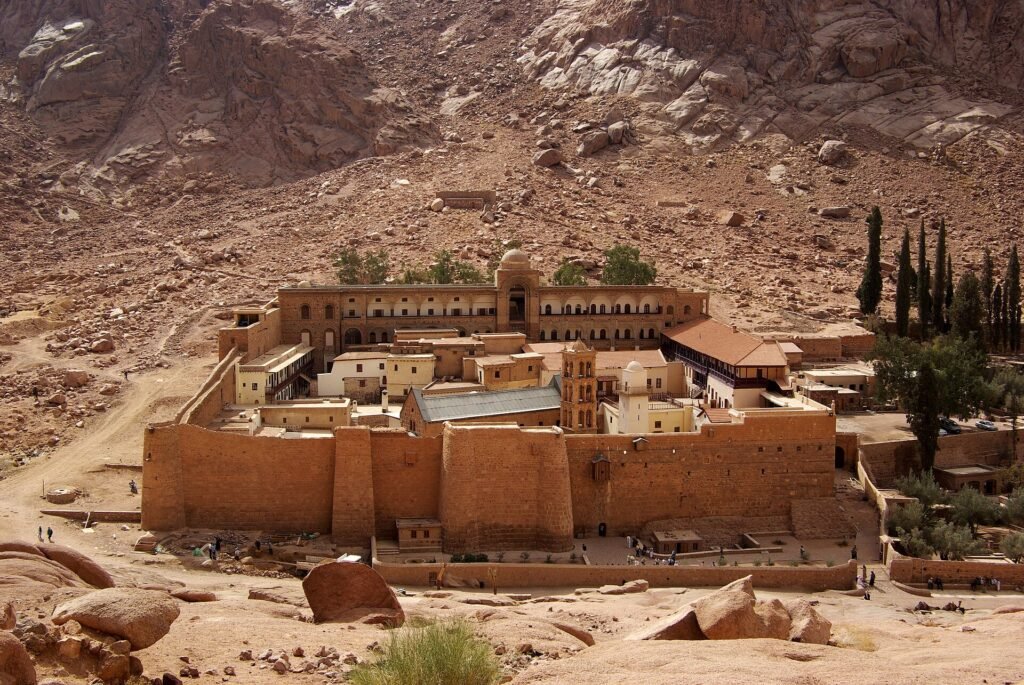 Monasterio de Santa Catalina con muros dorados al pie de las montanas de granito rojizo del Monte Sinai, Egipto, bajo luz calida y cielo despejado