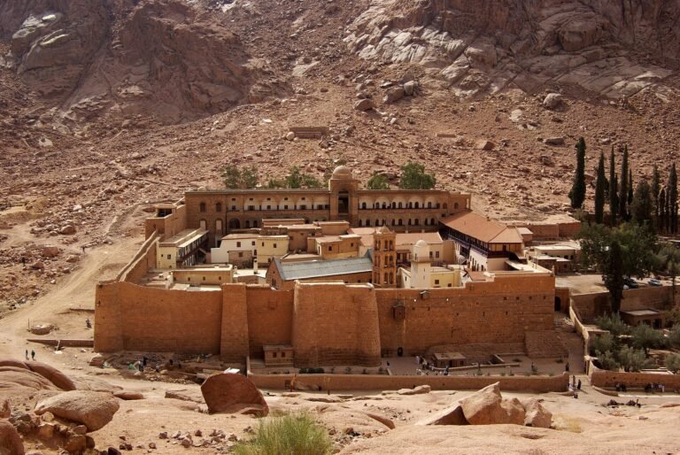 Monasterio de Santa Catalina con muros dorados al pie de las montanas de granito rojizo del Monte Sinai, Egipto, bajo luz calida y cielo despejado