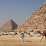 Paseo en camello frente a las pirámides de Giza bajo cielo despejado, El Cairo, Egipto