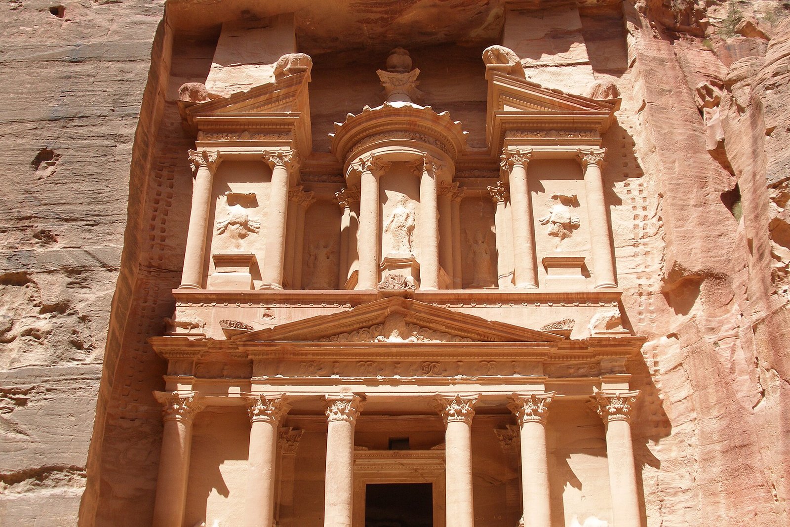 El Tesoro de Petra (Al-Khazneh) tallado en roca rosada en Jordania bajo luz dorada, corazon del lado jordano del combinado