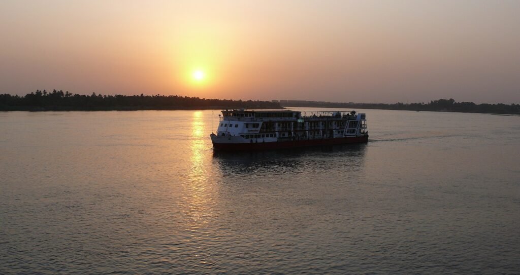 Barco de crucero por el Nilo navegando al atardecer en Egipto, ideal para ilustrar que llevar a un crucero por el Nilo