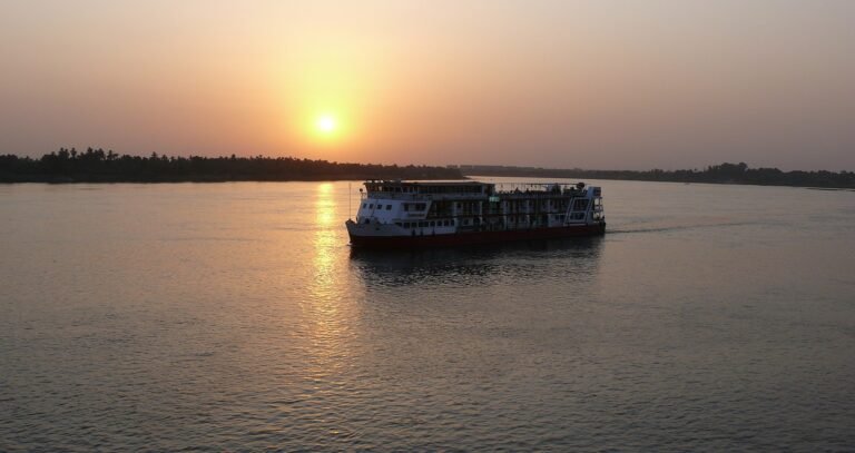 Barco de crucero por el Nilo navegando al atardecer en Egipto, ideal para ilustrar que llevar a un crucero por el Nilo