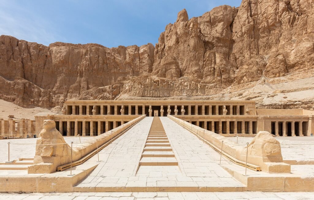 Templo de Hatshepsut en Deir el-Bahari visto de frente con su larga calzada, esfinges y columnatas escalonadas bajo los acantilados de Luxor en Egipto