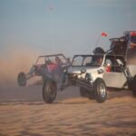 Dos buggies todoterreno cruzando a toda velocidad las dunas de arena del desierto levantando polvo, escena energica con luz dorada y colores premium