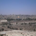 Vista panoramica de la Ciudad Vieja de Jerusalen desde el Monte de los Olivos con la Cupula de la Roca dorada, las murallas y las laderas con cipreses en Israel