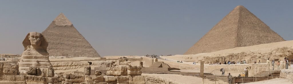 La Gran Esfinge de Giza junto a las pirámides de Kefrén y Keops en un día soleado, vista panorámica del recinto arqueológico