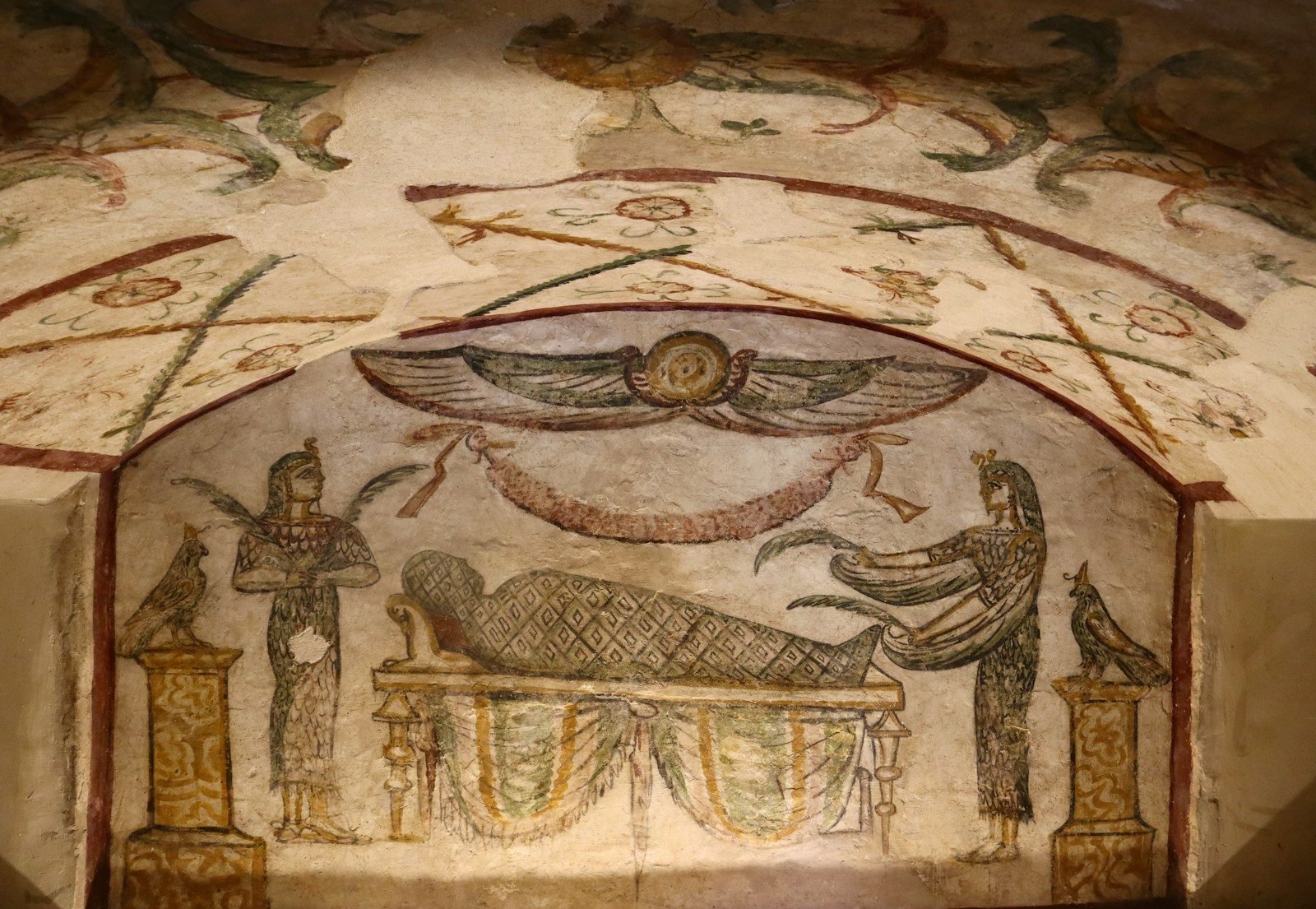 Graeco-Egyptian funerary painting in the catacombs of Kom el-Shoqafa, Alexandria, with the mummy on a bier between two divine figures