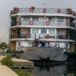 Two Nile cruise ships moored side by side, their railed decks hung with life rings