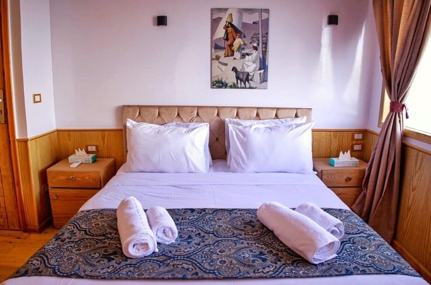 Cama doble con toallas dobladas en una cabina de la Akhenaton