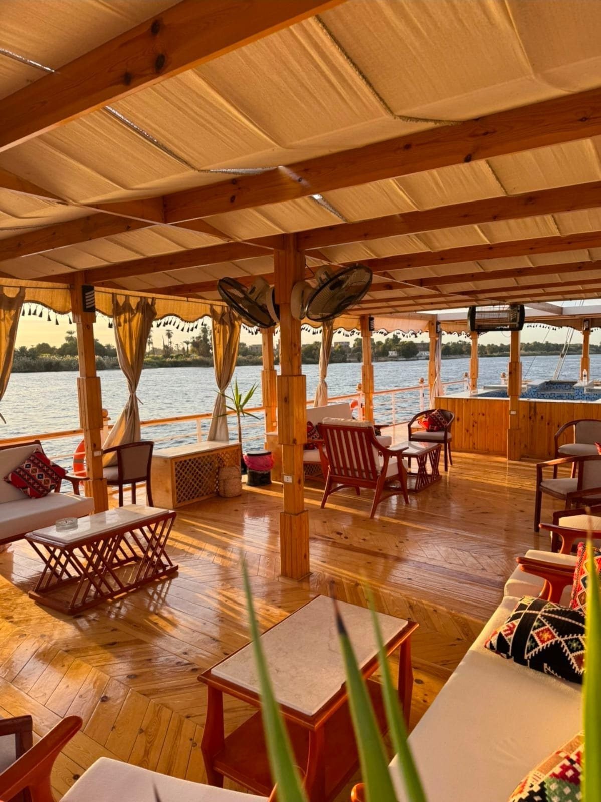 Terraza de la Akhenaton con sofás, cojines y mesas bajas a la luz de la tarde
