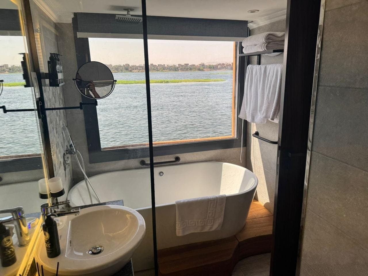 Cabin bathroom on the Iris with a freestanding tub beside a window onto the Nile