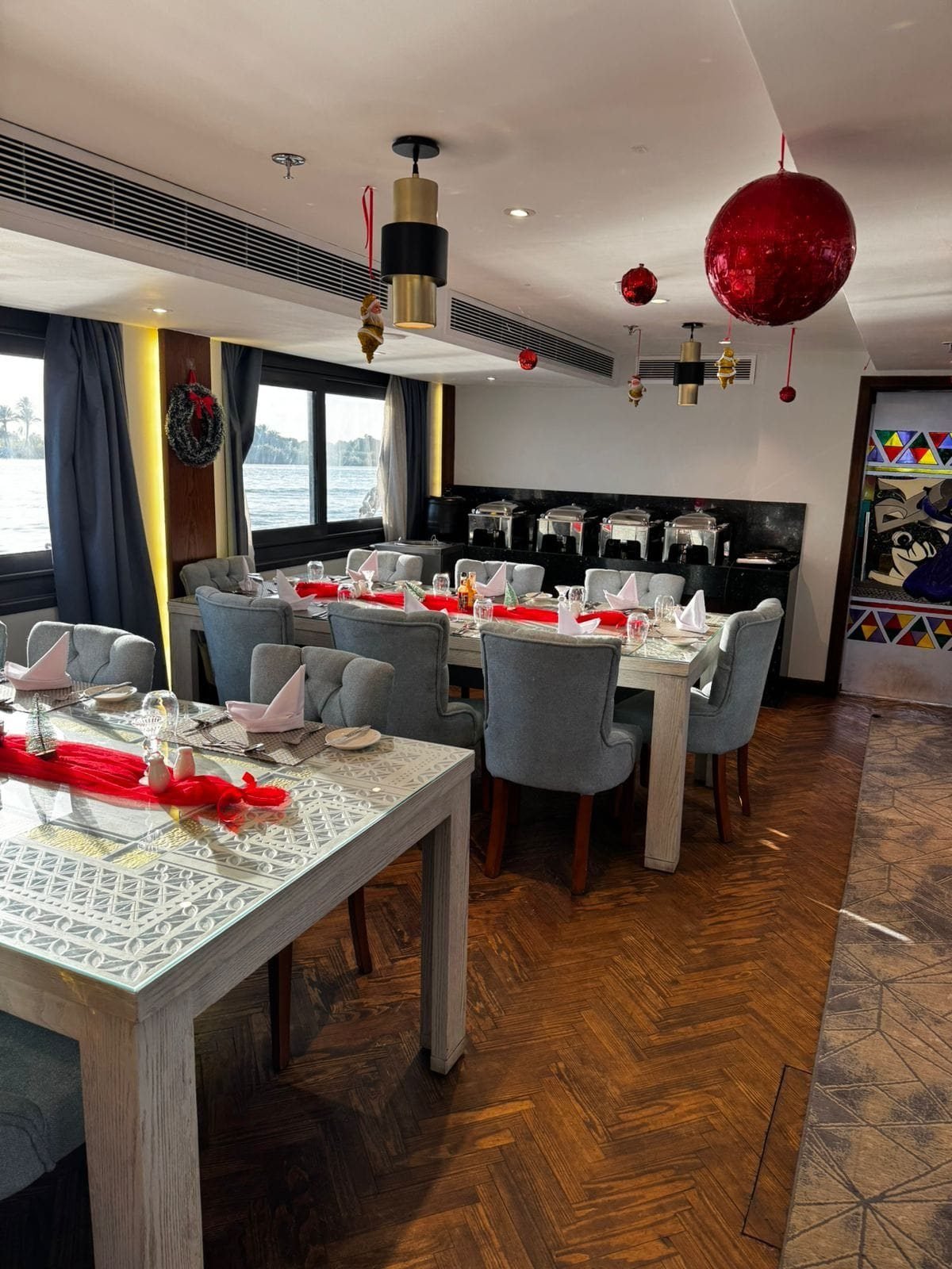 Indoor dining room on the Iris, tables set and decorated for the holidays