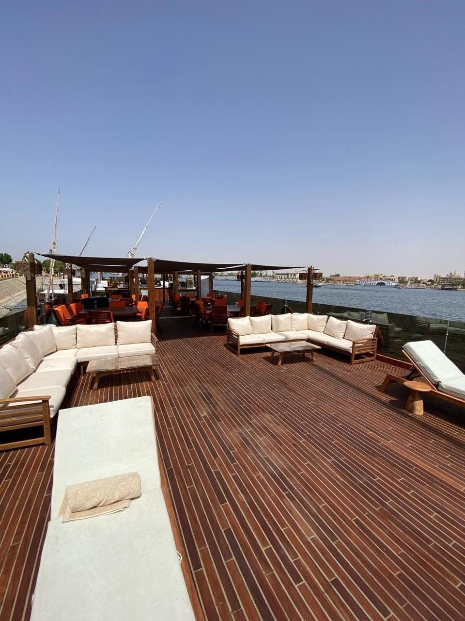 Upper deck of the Iris with open-air lounge areas and a wooden floor