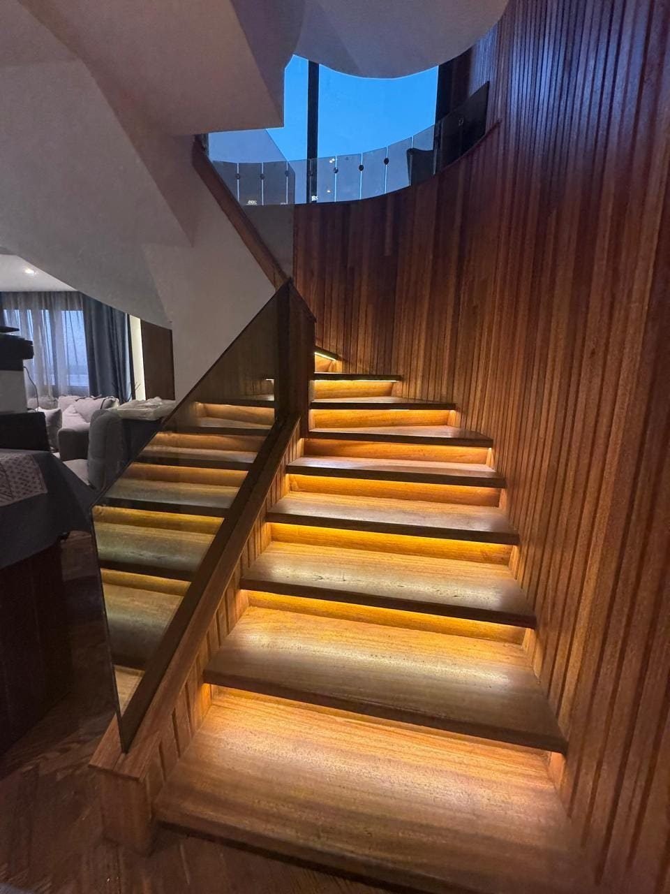 Lit wooden staircase between the decks of the Iris