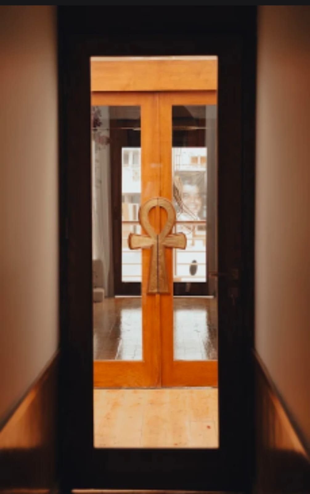 Puerta de madera y cristal de la Per-ba con tiradores en forma de cruz ankh
