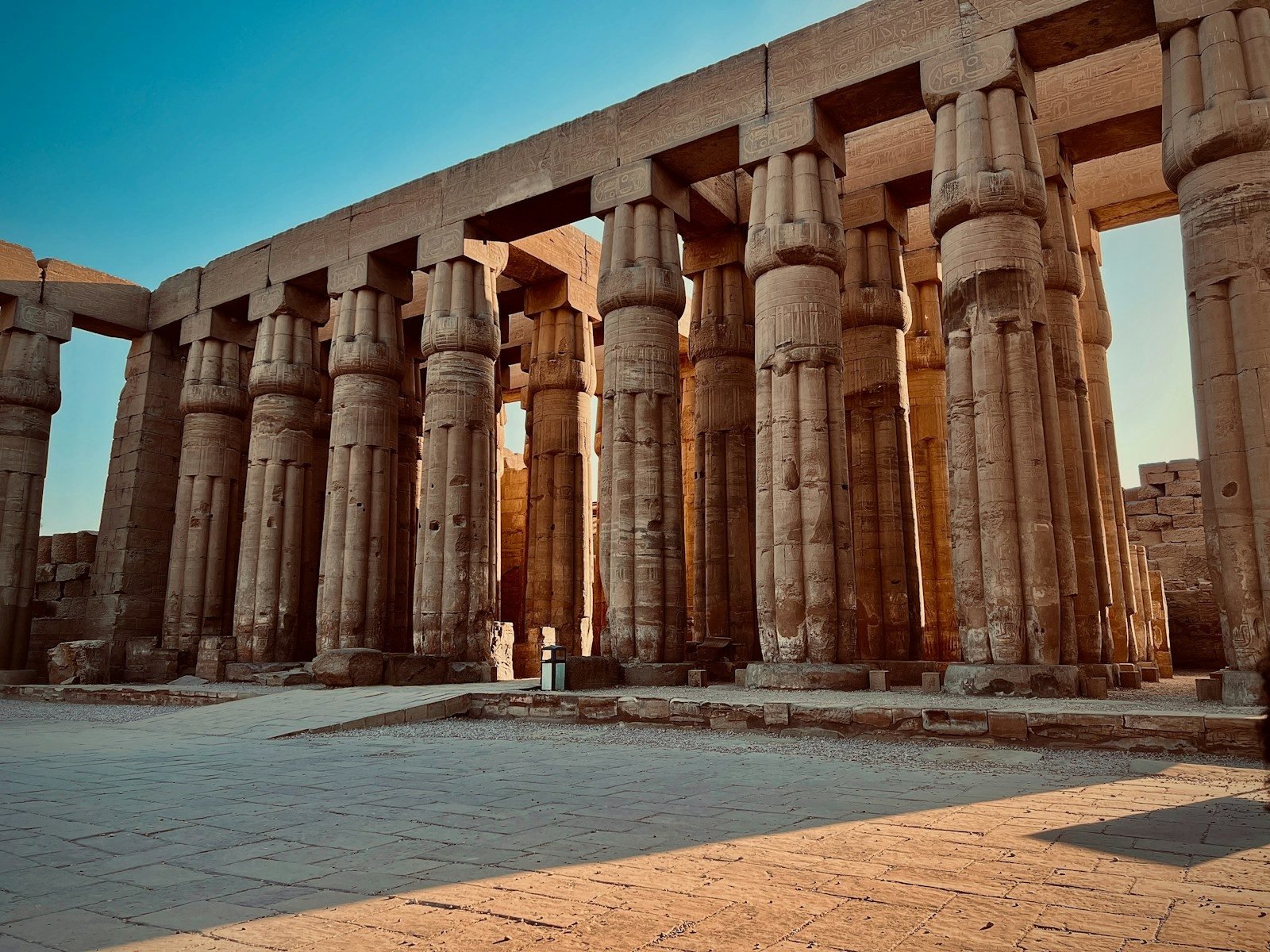 The papyrus-column colonnade of Luxor Temple under a deep blue sky