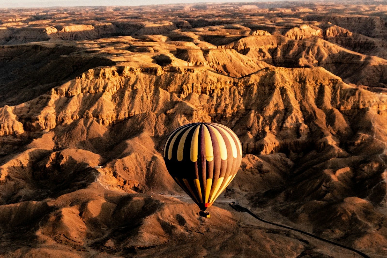 Un globo aerostático sobrevolando las montañas del desierto en la orilla oeste de Luxor.