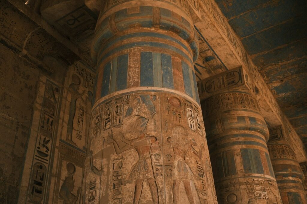Columnas de un templo egipcio con jeroglíficos y relieves que conservan su pintura azul y ocre