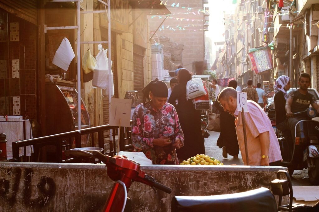 Un mercado callejero en El Cairo, con puestos de fruta y vecinos haciendo la compra