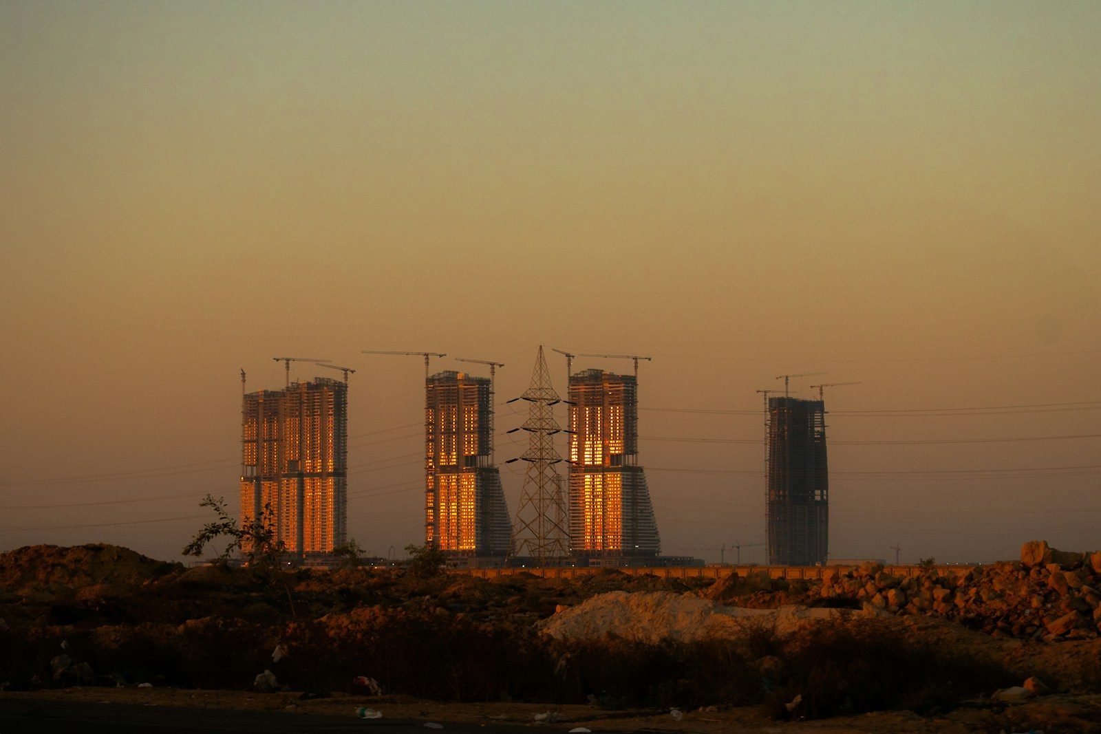 The towers of New Alamein lit by the evening sun, seen from the desert of the north coast