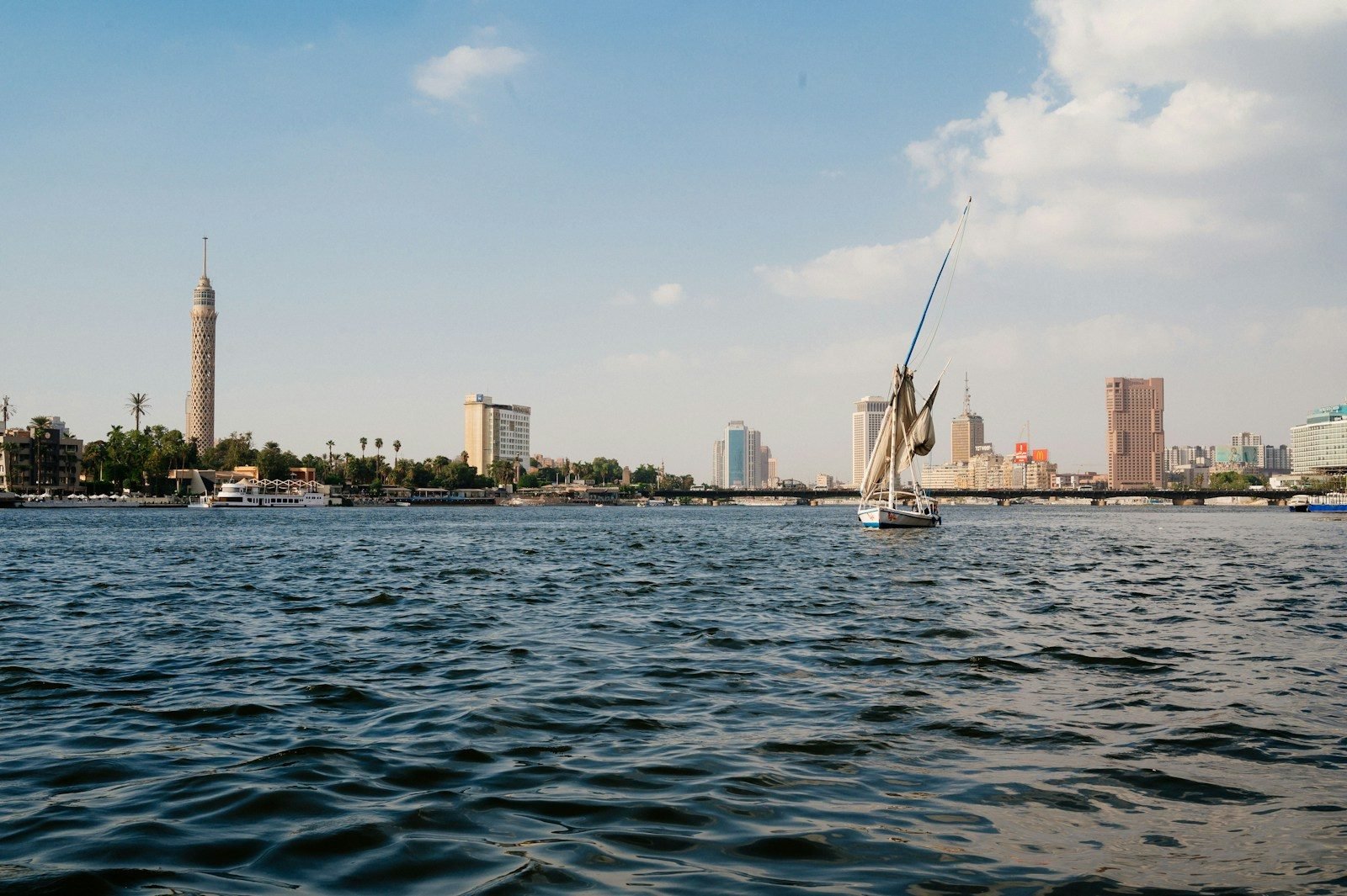 The Nile through Cairo, with a felucca on the water and the Cairo Tower in the distance.